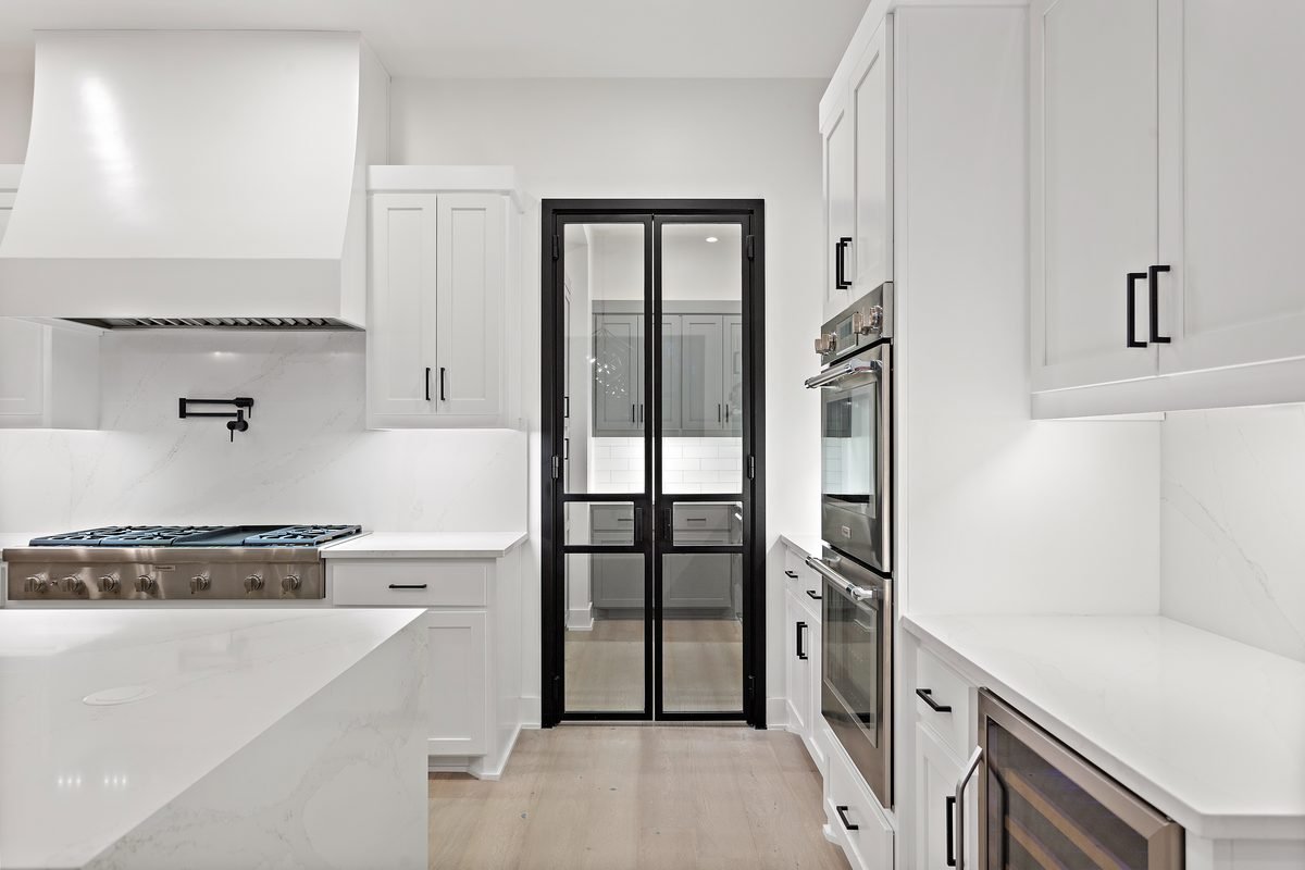 Kitchen with black steel-framed French doors and marble backsplash